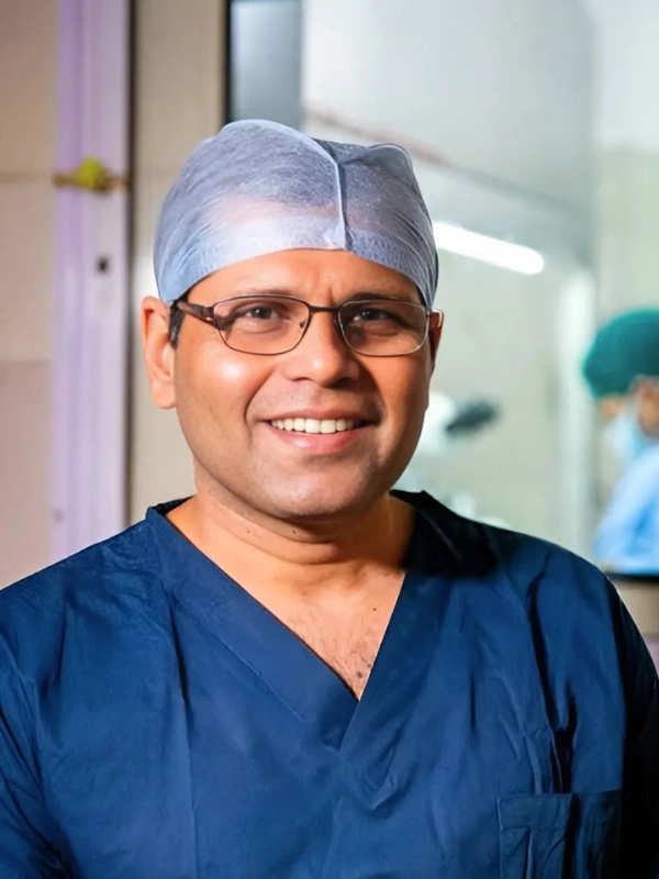 Headshot of Dr. Milind Colvalcar, a leading advanced cosmetic gynecology doctor in Goa, wearing a surgical cap.